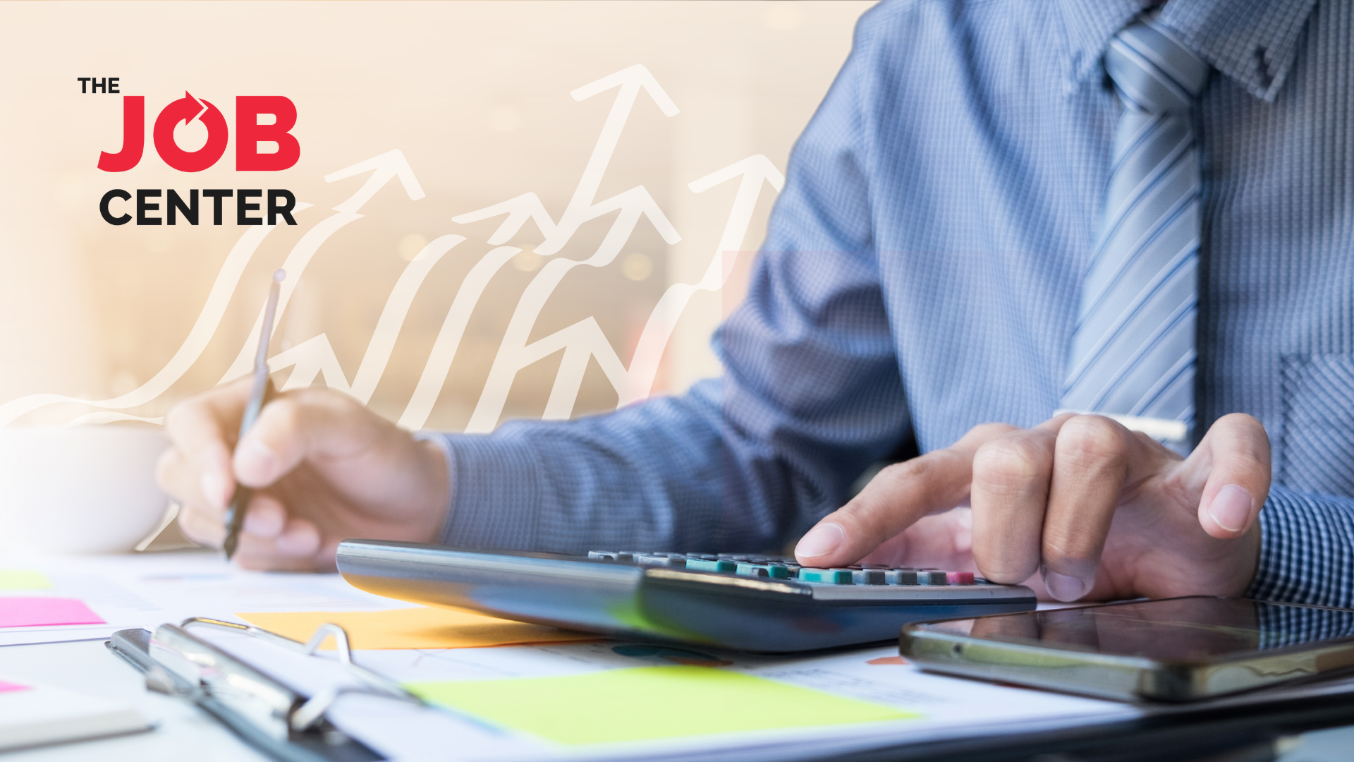 Man in corporate attire works out budget with a calculator, papers, and pen in hand