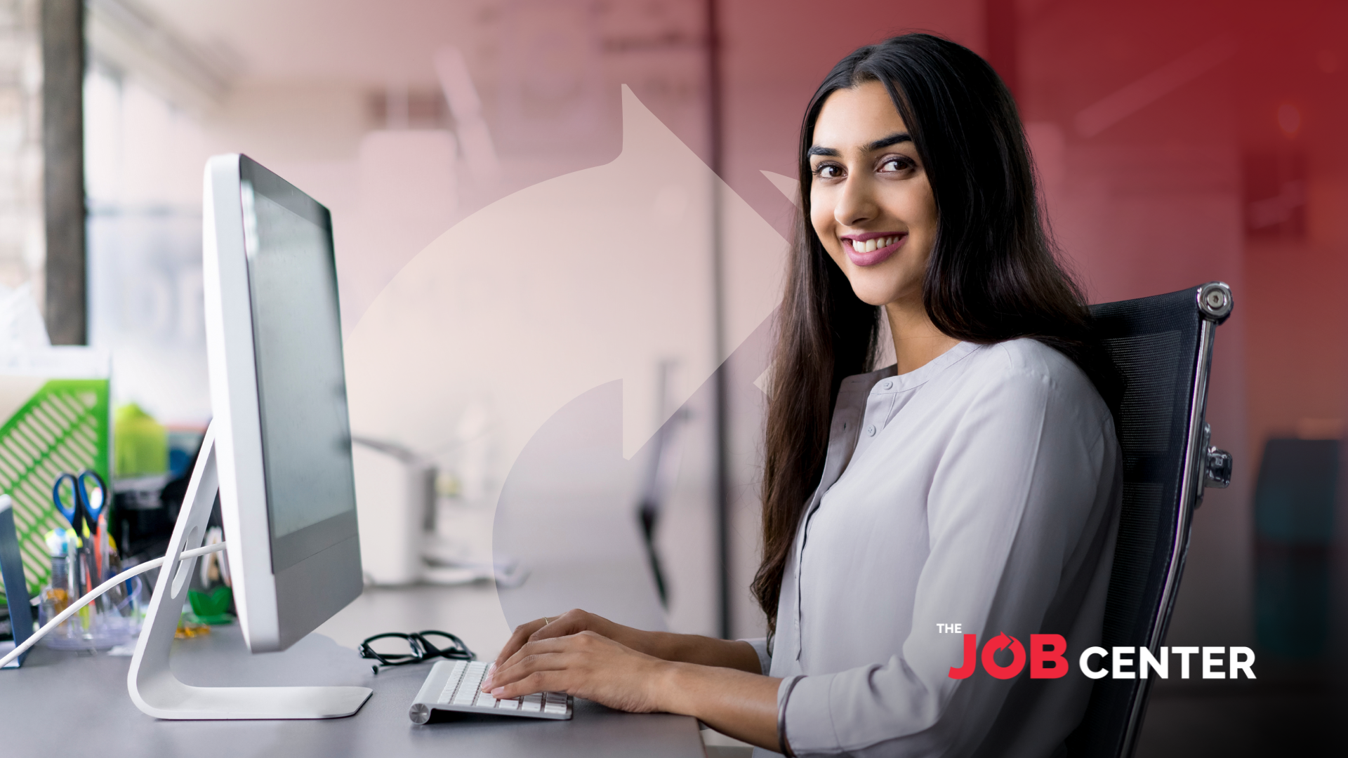 Woman in corporate attire at a long desk speaks to someone, gesturing to printed charts in her hand