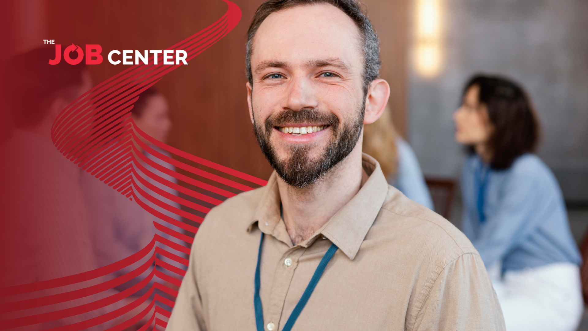 Man in corporate attire and ID strap smiles confidently